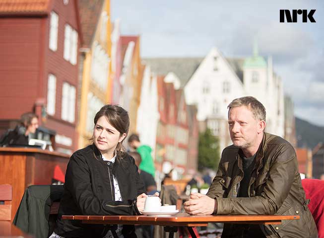 Bilde av to personer i serien Shetland, sittende på en kafé på Bryggen i Bergen