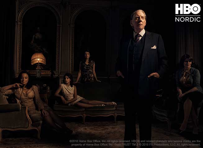 Donald Sutherland i rollen som J. Paul Getty Sr., stående, med fire kvinner fra hans "harem" sittende i bakgrunnen